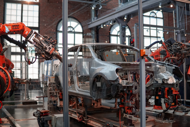 Production hall: welding robots working on a car body on an assembly line